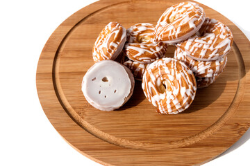 Sweet tasty cookies with white fondant on a wooden kitchen board.