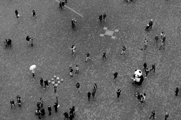 Set of people walking through a square