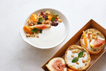 Homemade breakfast fresh colorful decoration mixed yogurt granola with mango, fig, cereal, rosemary, mint on white background