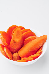 Raw chopped carrots in a white plate on a white background. Mockup. Photo for clipping. 