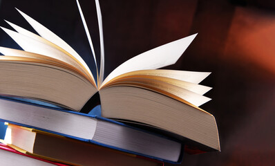 A composition with an open book lying on a stack of other books