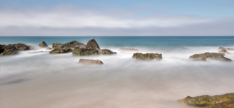 Long exposure image set of rocks hit by waves on a beach in southern Spain