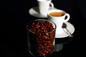 A cup of coffee with coffee beans in the foreground