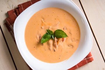 homemade tomato cream soup with basil leaf