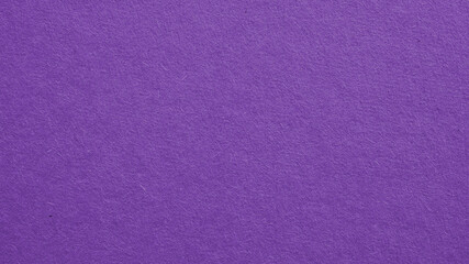 The surface of violet cardboard. Paper texture with cellulose fibers. Dark summer paperboard wallpaper. Bright purple tinted background. Saturated color. Top-down. Macro