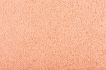 Orange fuzzy towel background. Fleecy fabric close up with space for text. Cozy material for bathroom towels or bathrobe