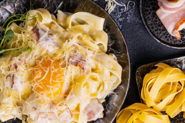 Carbonara pasta with egg sauce, bacon and grated parmesan cheese. Classic homemade pasta carbonara.