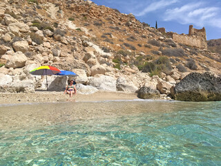 mujer tumbada en la arena en bikini debajo de la sombrilla en la playa san pedro almería cabo de...