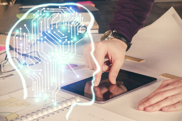 Double exposure of man's hand holding and using a digital device and brain hologram drawing. Data concept.