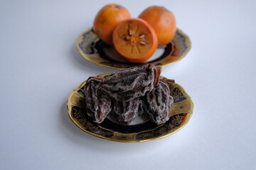 dried fruits. dried persimmon fruit on a plate. Kaki plum fruit, Japanese persimmon, Diospyros kaki Lycopersicum