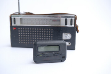 pager, old vintage beeper. the pager lies on an old retro radio with an antenna