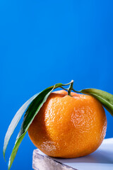 Fresh tangerine with leaves on a blue background