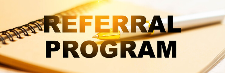 Referral program on the background of a pen and notebook before work in the early morning