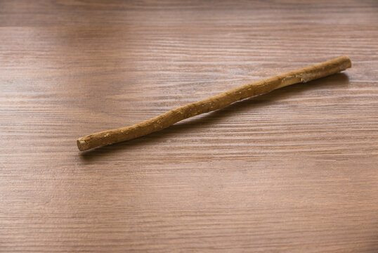 The miswak, miswaak, siwak, sewak, Arabic is a teeth cleaning twig made from the Salvadora persica tree. Miswak on wooden background.