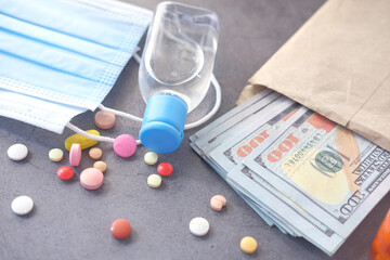 Healthcare cost concept with us dollar , container and pills on table 