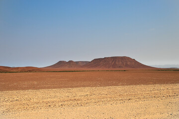 red mountain in a desertic landscape, blue sky, african landscape