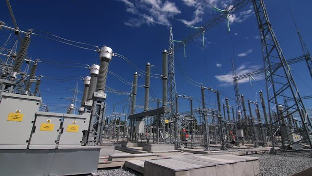 Hight supports and modern insulators with power transmission lines at electrical distribution substation under blue sky