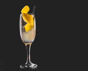 French 75 cocktail in a champagne flute on black background