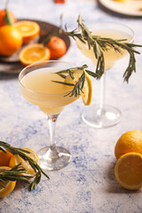 Yellow christmas alcoholic lemonade with oranges, tangerines and rosemary in margarita glasses