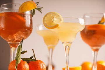 Orange christmas alcoholic beverage aperol spritz and lemonade with oranges, tangerines and rosemary in many glasses