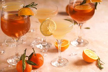 Orange christmas alcoholic beverage aperol spritz and lemonade with oranges, tangerines and rosemary in many glasses