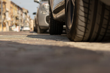 Pneumatico di automobile in primo piano parcheggiate sulla strada nel centro di una città Italiana