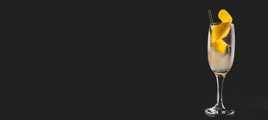 French 75 cocktail in a champagne flute on black background