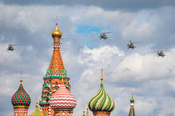 Fototapeta na wymiar MOSCOW, RUSSIA-MAY 7, 2021: a group of Russian military helicopters in the sky during a rehearsal for the Victory Day parade. View of St. Basil's Cathedral.
