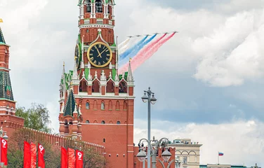 Tuinposter MOSCOW, RUSSIA-MAY 9, 2021: the Russian flag on the background of the Spasskaya Tower of the Moscow Kremlin in honor of the Victory Parade. © yulia_terekhina