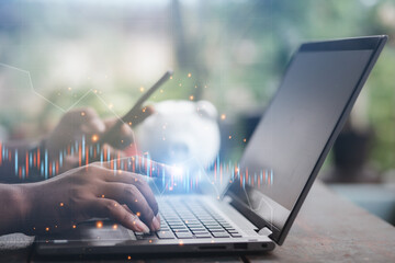 A business man is checking daily online stock market prices through a laptop at home with graphs...