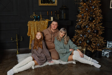 Obraz na płótnie Canvas Happy family on the floor by the Christmas tree.