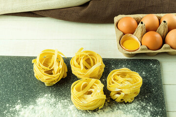 Twisted noodles and flour on the table