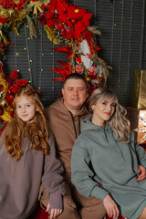 Beautiful and happy family at the New Year tree at a photo shoot.