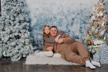 Happy father with his teenage daughter by the tree.