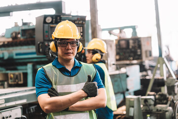 Portrait of Asian worker man  working in safety work wear with yellow helmet and glasses l ear muff...
