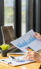 Businessman, accounting, calculating, analyzing, charting and graphing income with a modern laptop computer. And strategy ideas