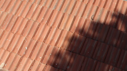 Orange color tile roof background. Close-up of the red clay texture of a house rooftop