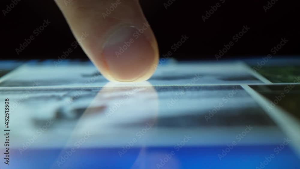 Wall mural close up macro man browsing tablet computer with finger. person using smartphone, browsing through p