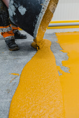 Worker applying epoxy and polyurethane flooring system