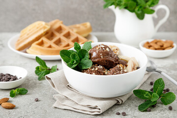 Chocolate and banana fruit ice cream with almond nuts served in bowl