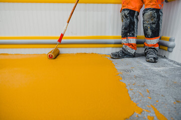 Worker applying epoxy and polyurethane flooring system