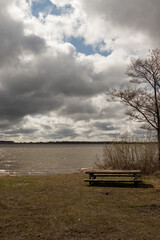 Obraz premium View of the shore of Lake Durbe with a tourist picnic lounge wooden table in the hall.