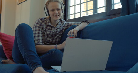 Woman on the sofa at home having video chat