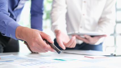 Asian business people meeting new startup project pointing graph discussion and analysis data charts and graphs.Business finances and accounting concept