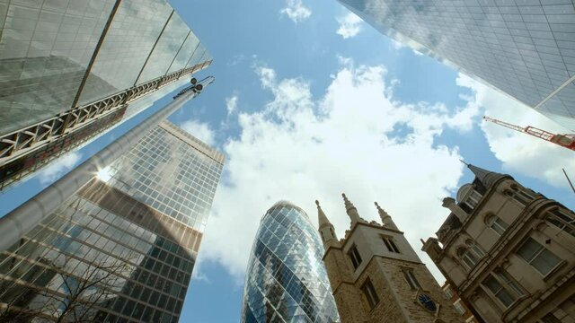 Bottom-up rotating shot of important and futuristic skyscrapers in the financial center of London, England, UK