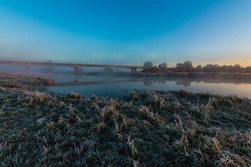 Obraz premium bridge over the Narew river during sunrise