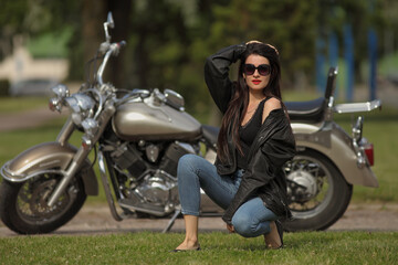 Naklejka na ściany i meble Portrait of young woman on a motorcycle