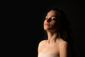 Closeup studio portrait of a sensual woman posing in the dark