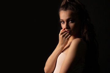 Closeup studio portrait of a romantic woman posing in the dark