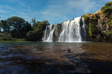 Fototapeta premium Beautiful slow shutter waterfall in Nelspruit South Africa, Water Cascading down a mountain side over the rocky terrain